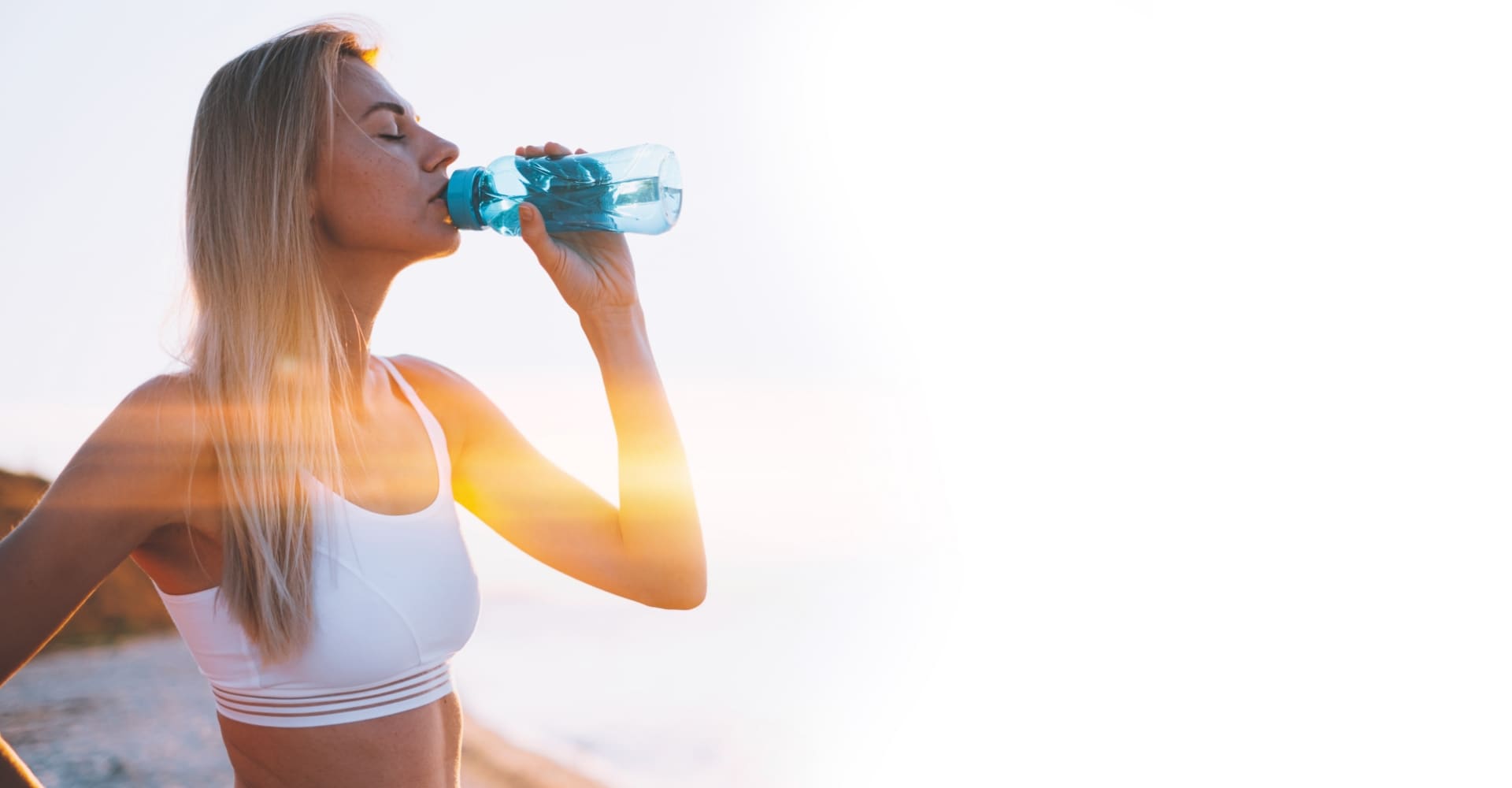 Woman in activewear drinking water on a bottle