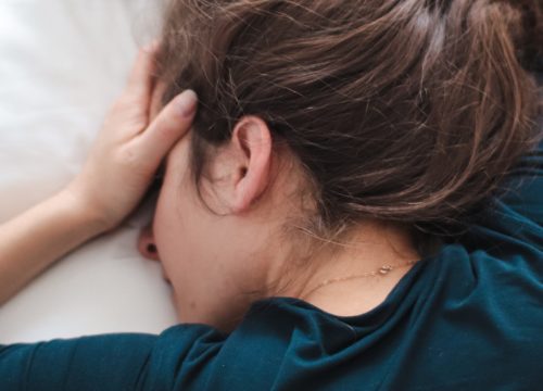 Photo of a woman in bed experiencing a hangover