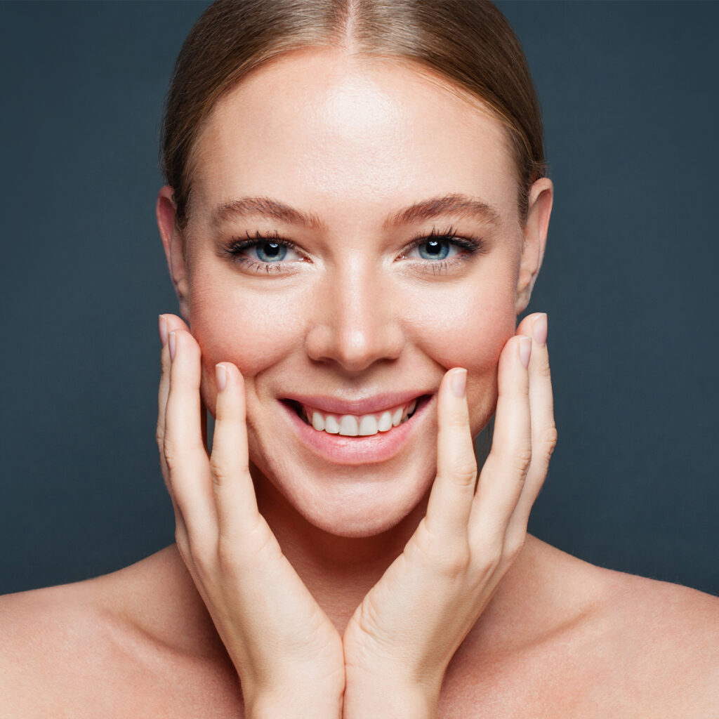 Photo of a happy woman touching the sides of her face